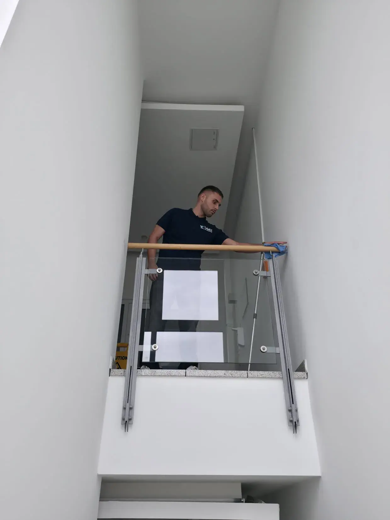 Veliz-Mitarbeiter beim Abwischen eines Handlaufs im Treppenhaus