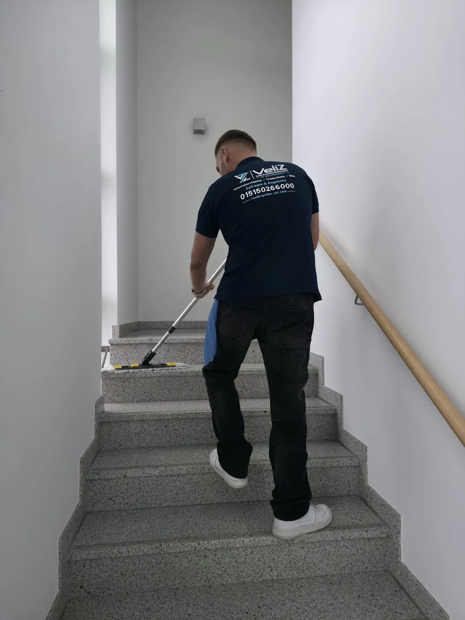 Veliz-Mitarbeiter beim Wischen von Treppenstufen in einem Treppenhaus