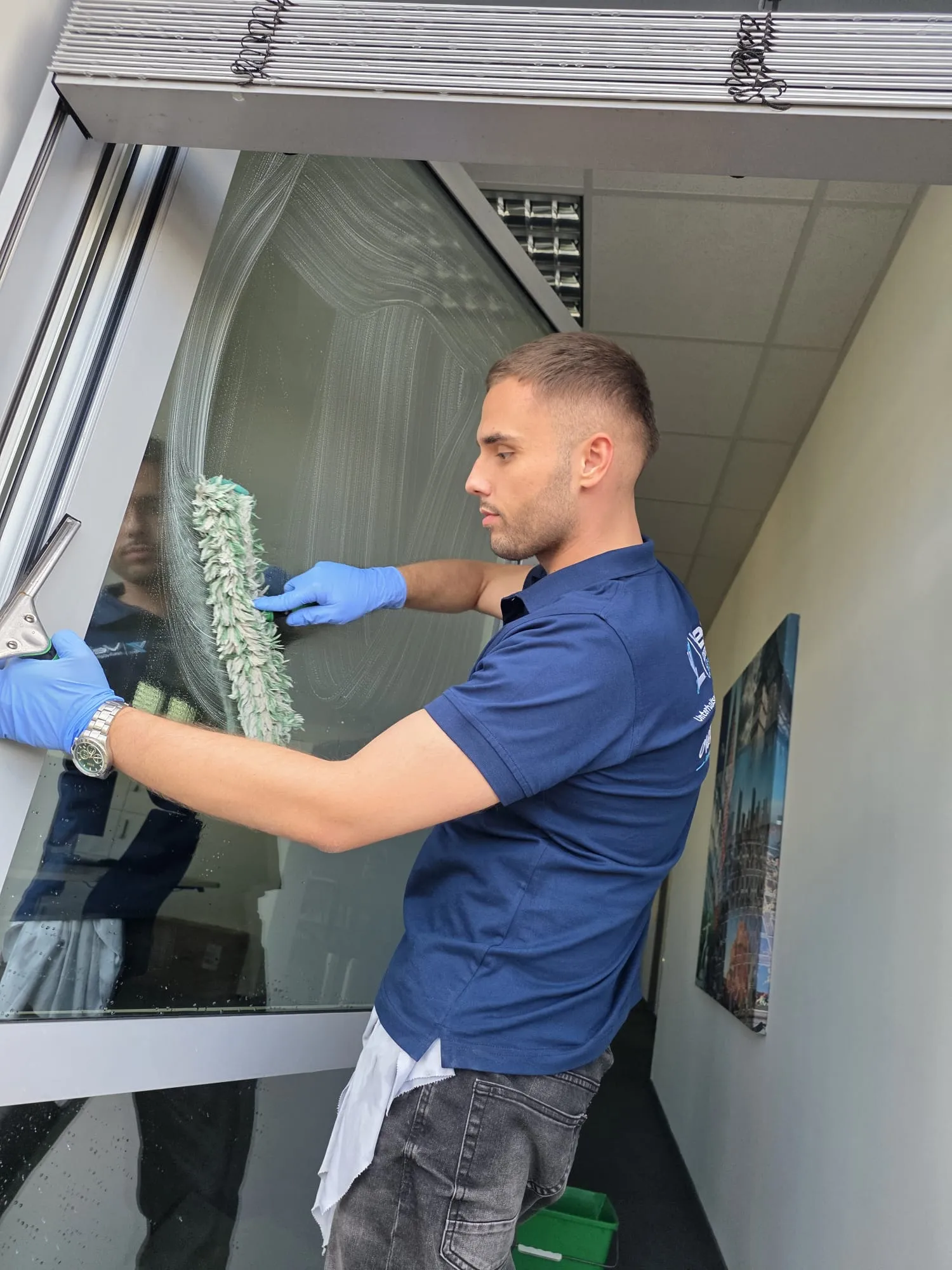 Veliz-Mitarbeiter bei der Reinigung eines Bürofensters mit Einwascher und Abzieher