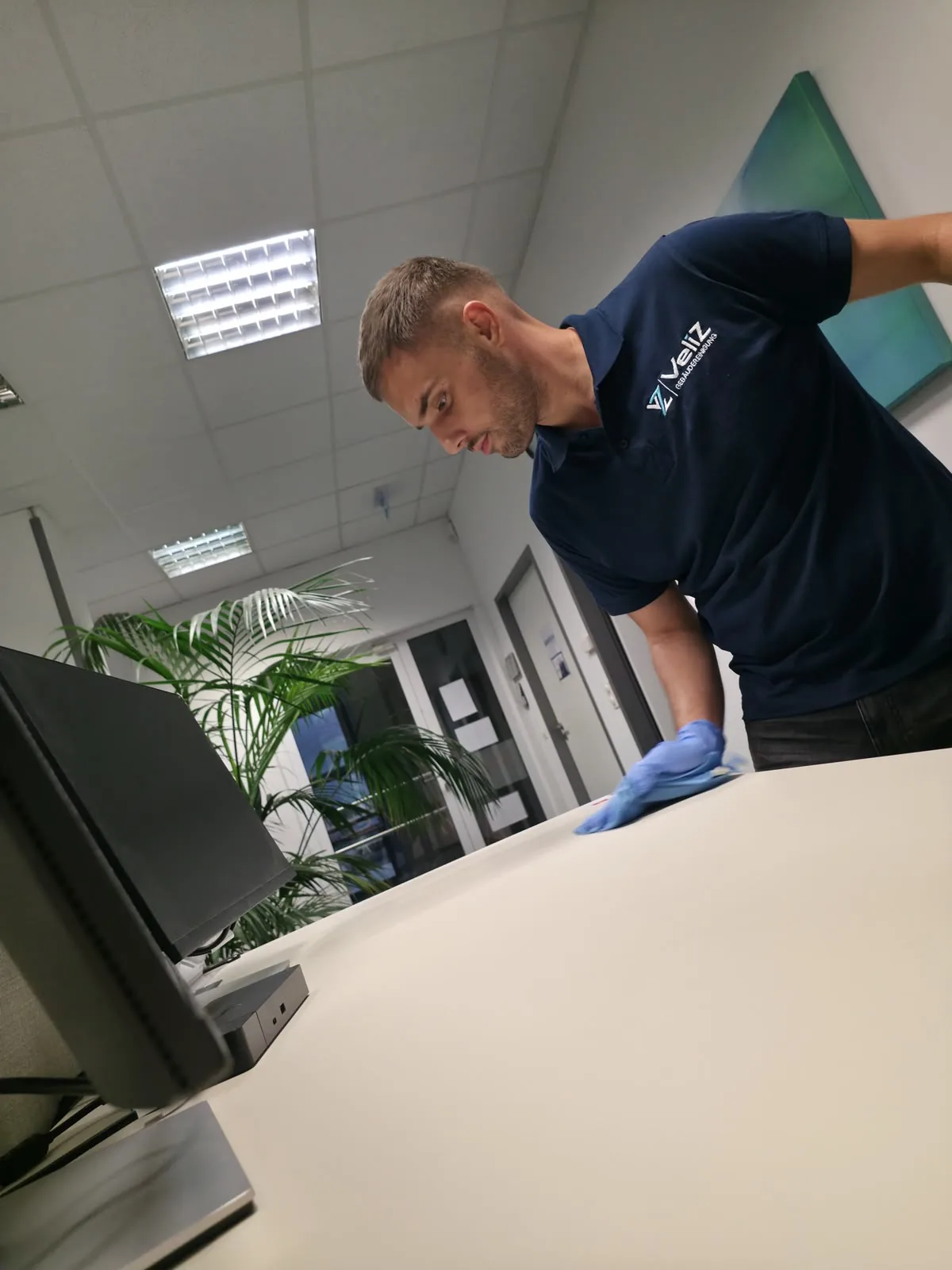 Veliz-Mitarbeiter beim Abwischen eines Schreibtischs in einem Büro
