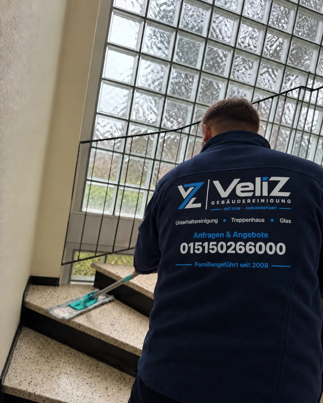 Veliz-Mitarbeiter beim Wischen einer Treppe im Treppenhaus